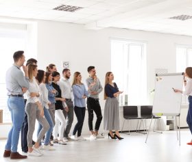 Stehende Personen beim Flipchart in einem Training