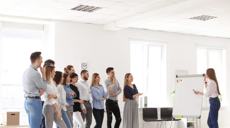 Stehende Personen beim Flipchart in einem Training